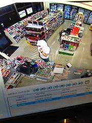 A suspected robber is seen wrapped in a white garment in a still frame of surveillance video from the store. (via Bay City News)